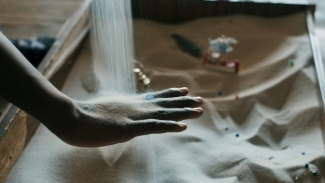 du sable glisse sur la main d'un enfant